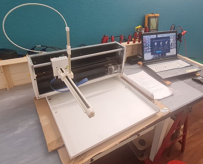 Geöffneter Autosampler auf der Werkbank, daneben ein Laptop mit Diagnosesoftware